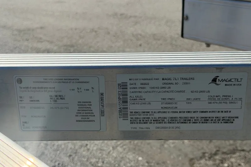 Slide: The Image of Magic Tilt trailer label with tire and loading information, showing specifications and compliance details. - 36
