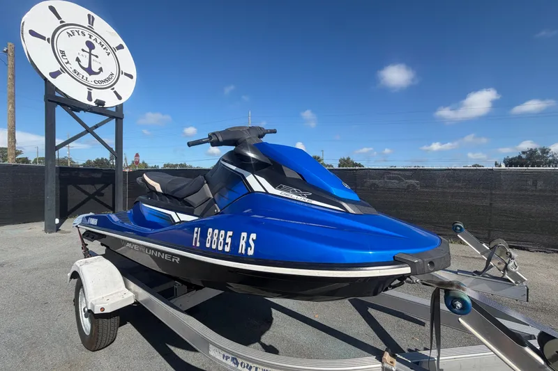 Slide: The Image of A blue 2018 Yamaha WaveRunner EX Deluxe on a trailer in front of a sign. - 0
