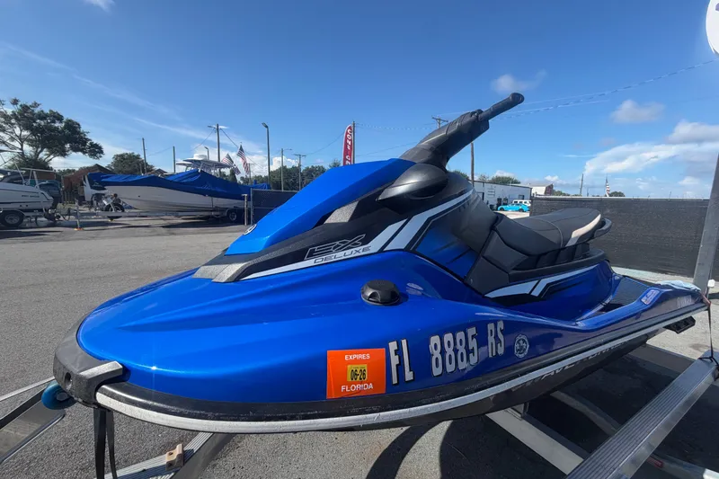 Slide: The Image of 2018 Yamaha WaveRunner EX Deluxe in blue, parked on a trailer under a clear sky. - 7