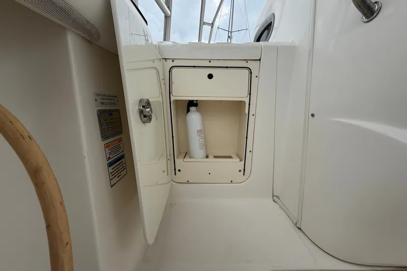 Slide: The Image of 2007 Boston Whaler 320 Outrage storage compartment with a bottle inside. - 35