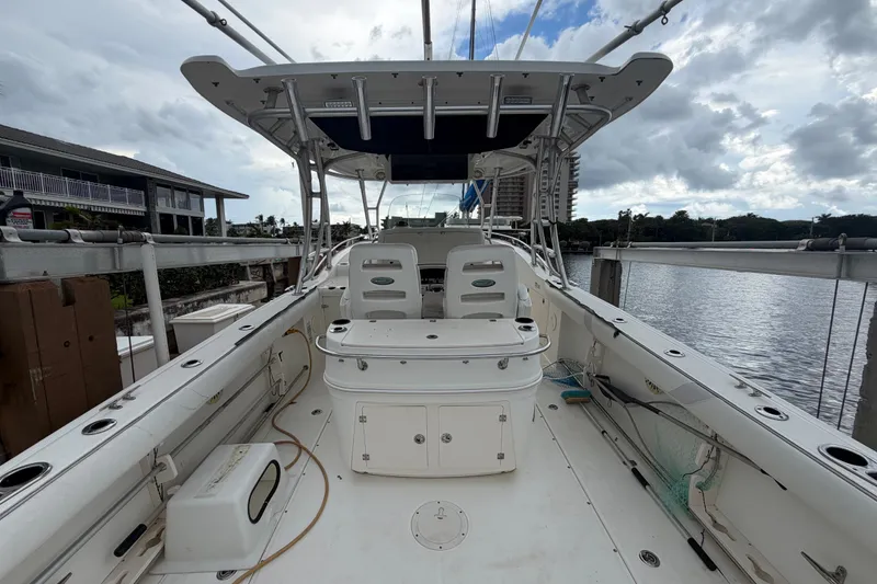 Slide: The Image of 2007 Boston Whaler 320 Outrage boat docked, showcasing spacious deck and seating area. - 16