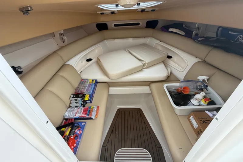 Slide: The Image of 2007 Boston Whaler 320 Outrage cabin interior with beige seating and storage items. - 54