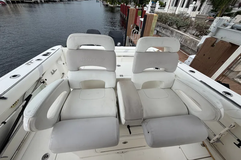 Slide: The Image of 2007 Boston Whaler 320 Outrage boat seats, white leather, docked by waterfront. - 23