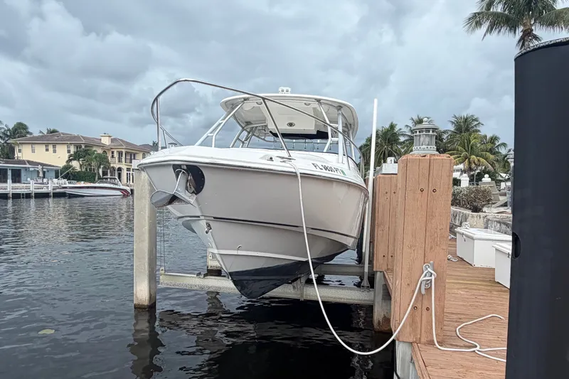 Slide: The Image of 2007 Boston Whaler 320 Outrage docked at a marina with palm trees in the background. - 5