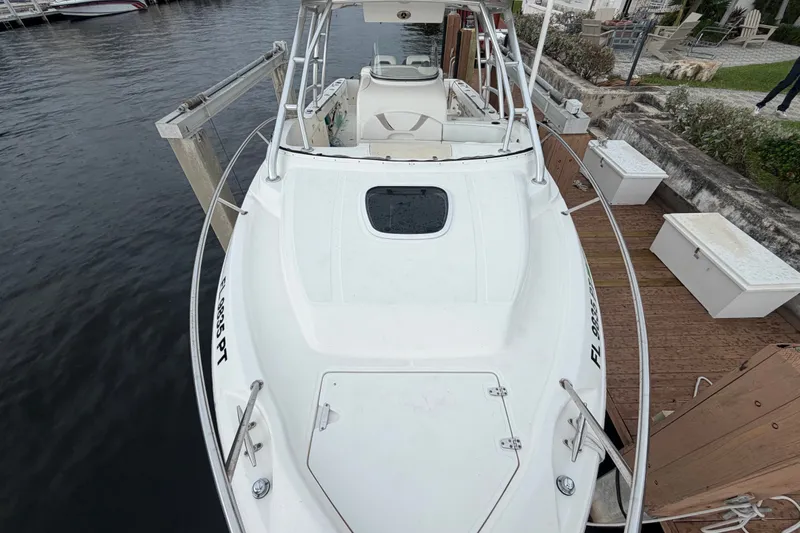 Slide: The Image of 2007 Boston Whaler 320 Outrage docked, showcasing sleek design and spacious deck. - 11