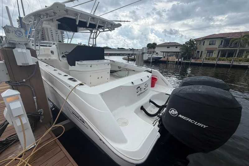 Slide: The Image of 2007 Boston Whaler 320 Outrage docked, featuring dual Mercury engines, under a cloudy sky. - 3