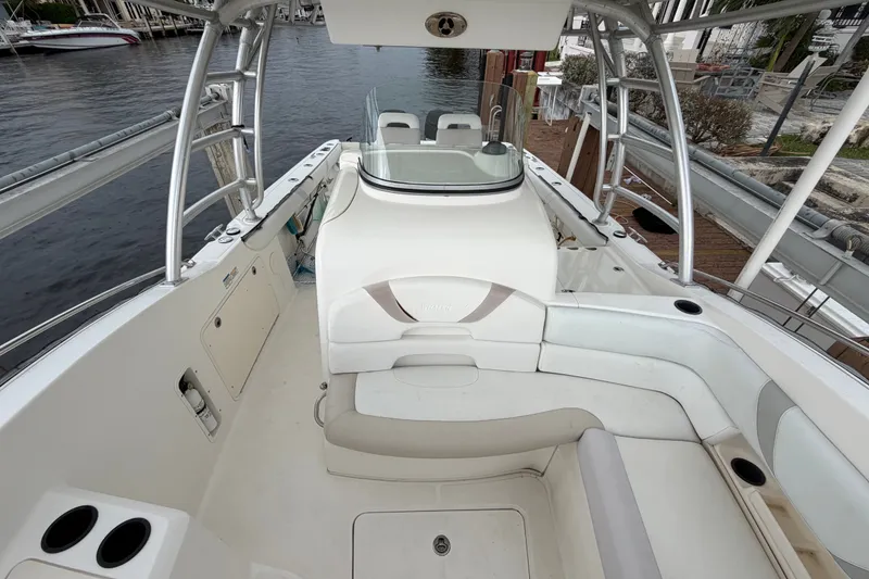 Slide: The Image of 2007 Boston Whaler 320 Outrage boat interior with seating and helm, docked by the water. - 14