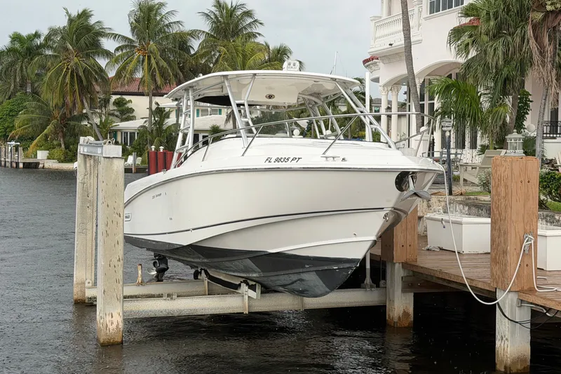 Slide: The Image of 2007 Boston Whaler 320 Outrage docked near waterfront home with palm trees. - 0