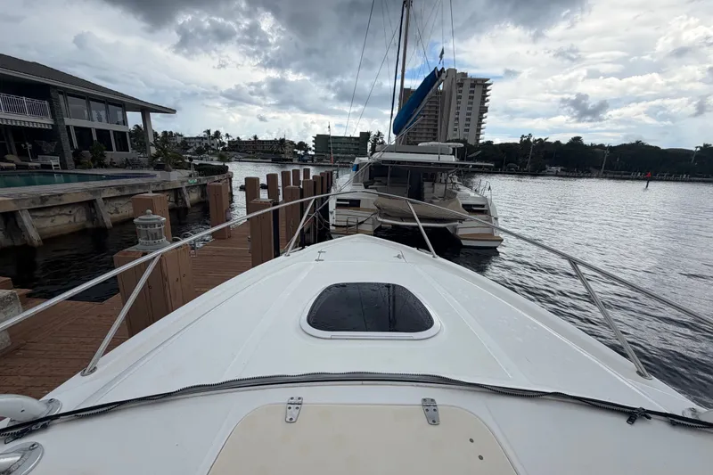 Slide: The Image of 2007 Boston Whaler 320 Outrage docked near waterfront homes under cloudy skies. - 7