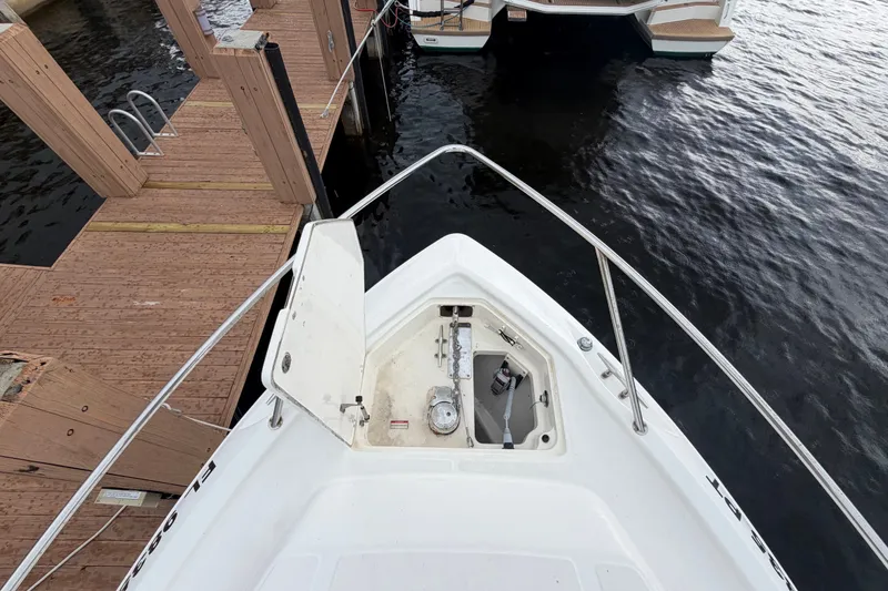 Slide: The Image of 2007 Boston Whaler 320 Outrage bow view at dock, showcasing anchor compartment. - 10