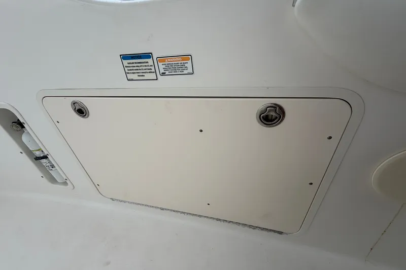 Slide: The Image of 2007 Boston Whaler 320 Outrage storage compartment with safety labels. - 41