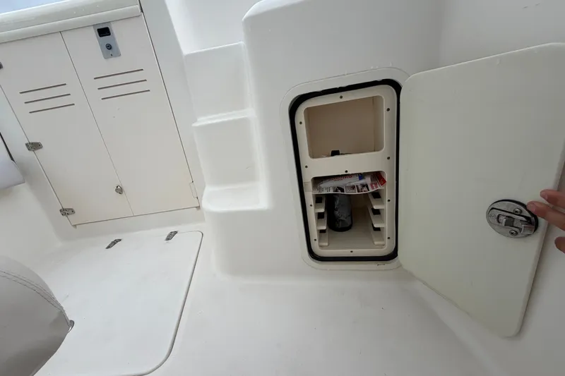 Slide: The Image of 2007 Boston Whaler 320 Outrage interior storage compartment with open hatch and visible contents. - 45