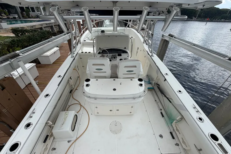 Slide: The Image of 2007 Boston Whaler 320 Outrage boat interior, docked by the water, showcasing seating and controls. - 15