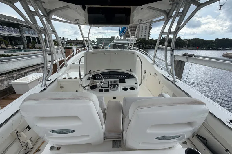 Slide: The Image of 2007 Boston Whaler 320 Outrage boat interior with helm and seating, docked by the water. - 21
