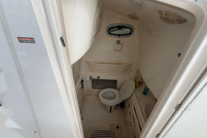 Slide: The Image of 2007 Boston Whaler 320 Outrage boat bathroom interior with toilet and storage. - 39