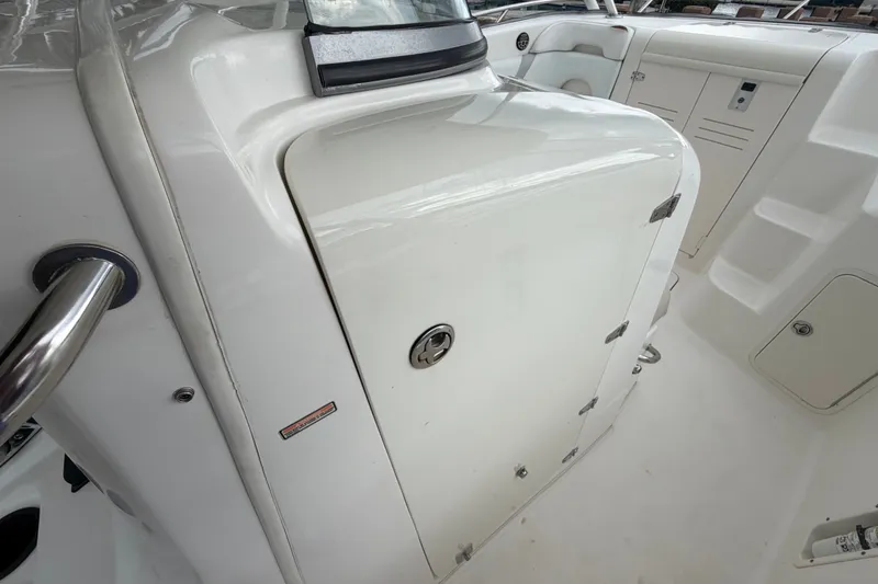 Slide: The Image of 2007 Boston Whaler 320 Outrage interior, featuring sleek white cabinetry and stainless steel accents. - 38