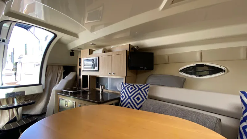 Slide: The Image of Interior of 2015 Monterey 295 Sport Yacht with kitchenette, seating, and porthole window. - 33