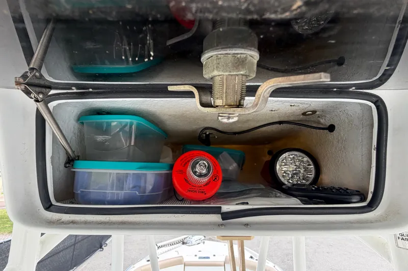 Slide: The Image of Un compartiment de rangement avec une lampe de poche, des conteneurs et une lampe sur un bateau. - 33