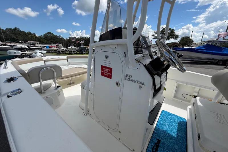 Slide: The Image of De afbeelding toont een NauticStar 231 Coastal boot uit 2015 met een stuurstand en blauwe tapijten. - 34