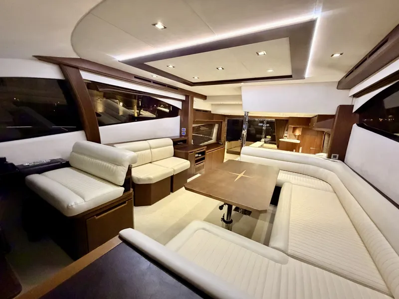 Slide: The Image of Interior of the 2016 Galeon 550 Fly with elegant white leather sofas and a wooden table. - 28