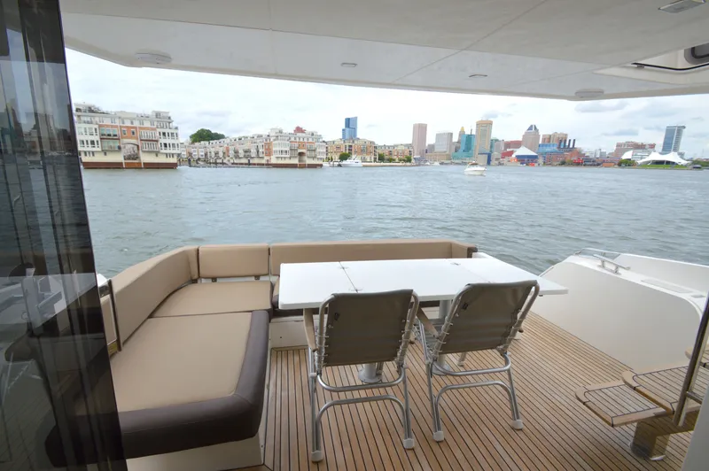 Slide: The Image of 2016 Galeon 550 Fly with spacious deck, seating area, and table, overlooking the skyline. - 20