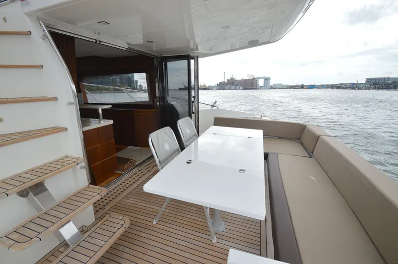 Slide: The Image of 2016 Galeon 550 Fly with spacious deck, dining table, seating area, and water view. - 18