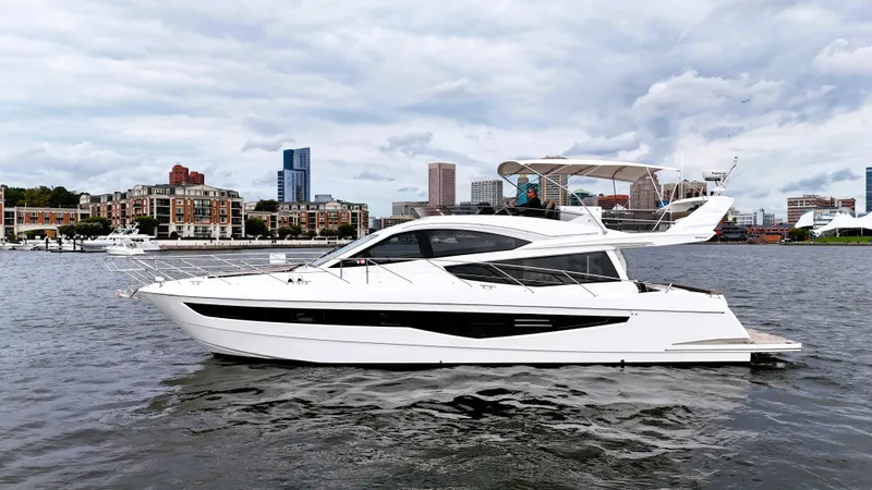 The Image of The 2016 Galeon 550 Fly cruising on a river with an urban skyline in the background. - 0