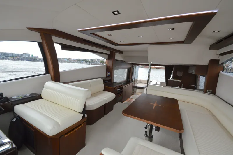 Slide: The Image of Interior of the 2016 Galeon 550 Fly with elegant white seating and wooden table. - 38