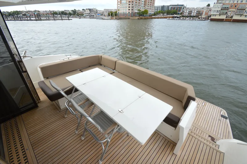 Slide: The Image of The image shows the stern of a 2016 Galeon 550 Fly with an elegant seating area and table. - 17