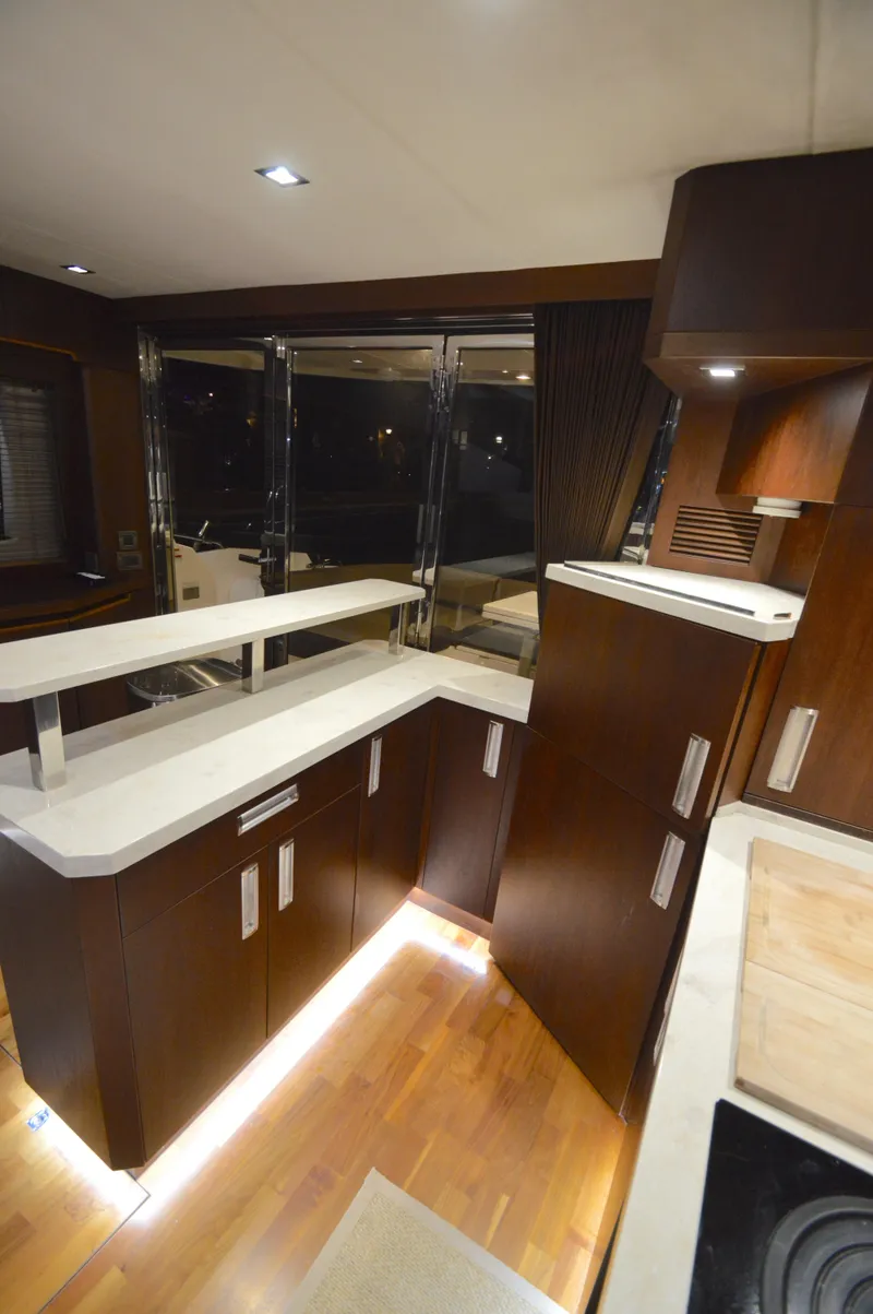 Slide: The Image of Interior of the 2016 Galeon 550 Fly featuring a modern kitchen and wood paneling. - 24