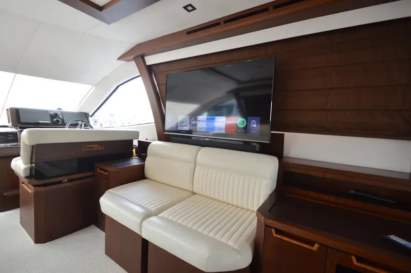 Slide: The Image of Interior of the 2016 Galeon 550 Fly with beige sofa and large TV. - 37