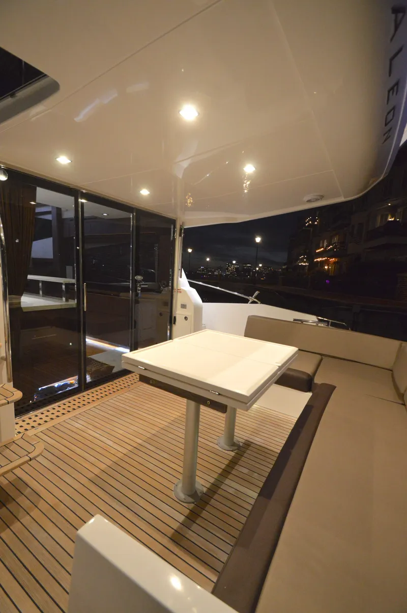 Slide: The Image of The 2016 Galeon 550 Fly features an elegant deck with a table and seating area. - 13