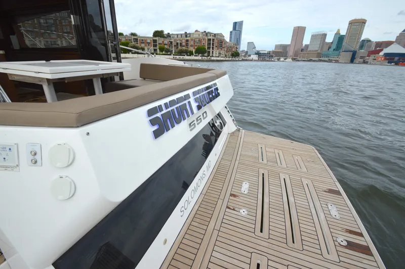 Slide: The Image of Rear view of a 2016 Galeon 550 Fly with a cityscape in the background. - 14