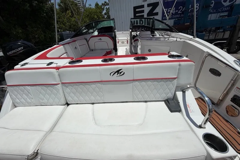 Slide: The Image of 2017 Monterey M-65 boat interior with white and red seating, cup holders, and sleek design. - 50