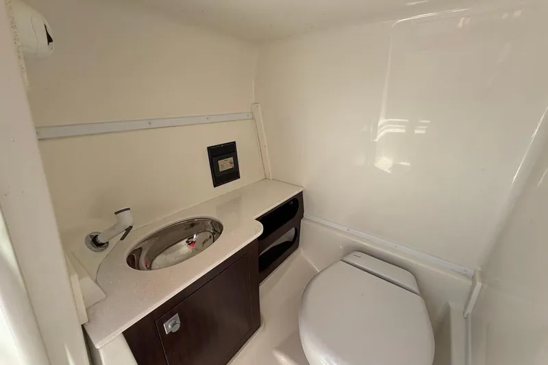 Slide: The Image of 2017 Monterey M-65 boat bathroom with sink, toilet, and storage cabinet. - 75