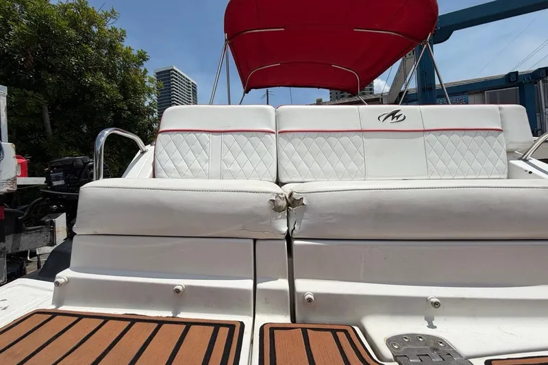 Slide: The Image of White Monterey M-65 boat seat with red canopy, showing visible damage, 2017 model. - 39