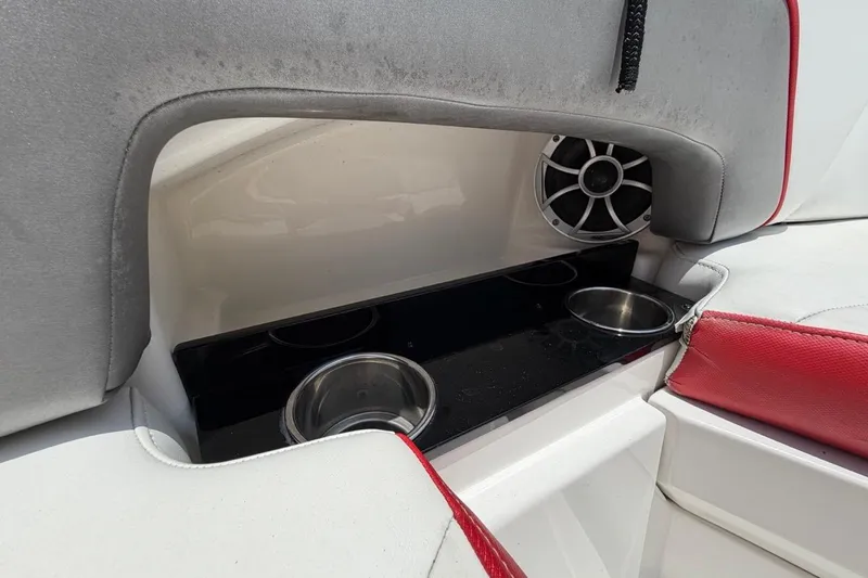 Slide: The Image of 2017 Monterey M-65 boat interior with cup holders and speaker, featuring red and gray seating. - 89