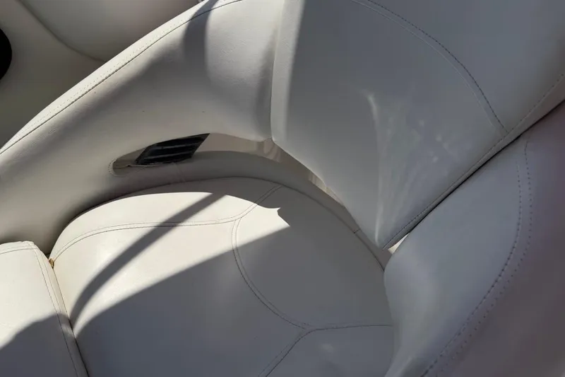 Slide: The Image of White leather seat of a 2017 Monterey M-65 boat, showcasing stitching details. - 114