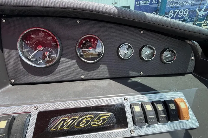 Slide: The Image of Dashboard of a 2017 Monterey M-65 boat with gauges and switches. - 72