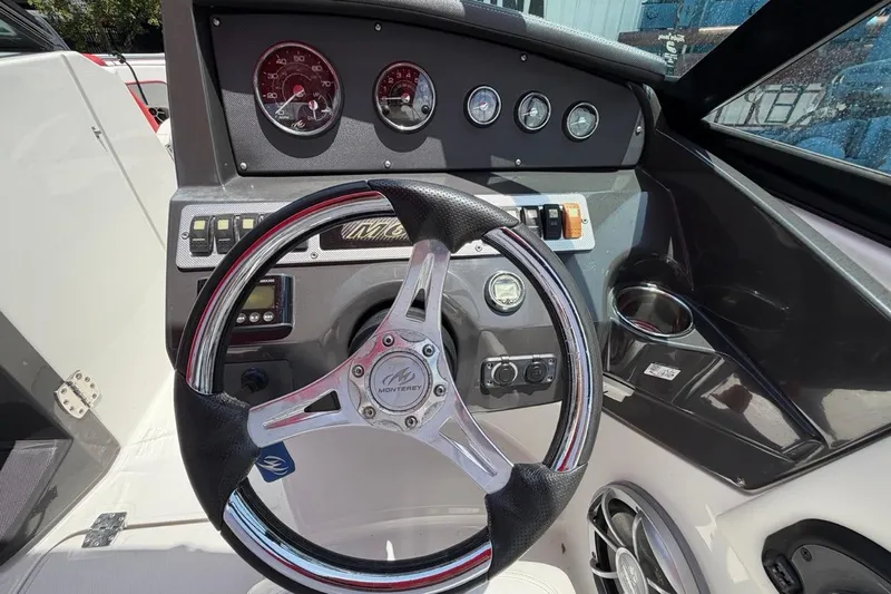 Slide: The Image of Steering wheel and dashboard of a 2017 Monterey M-65 boat, featuring gauges and controls. - 70