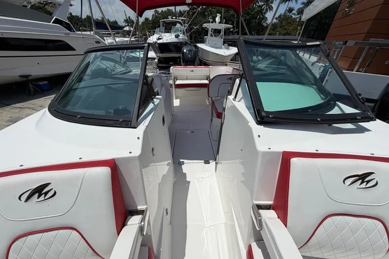 Slide: The Image of 2017 Monterey M-65 boat interior with red and white seating, docked among other boats. - 95
