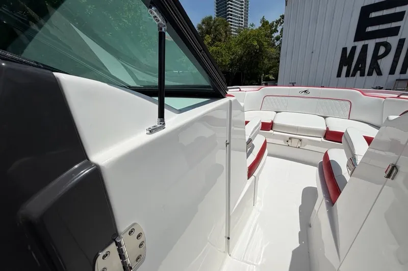 Slide: The Image of 2017 Monterey M-65 boat interior with white and red seating, docked near marina. - 83