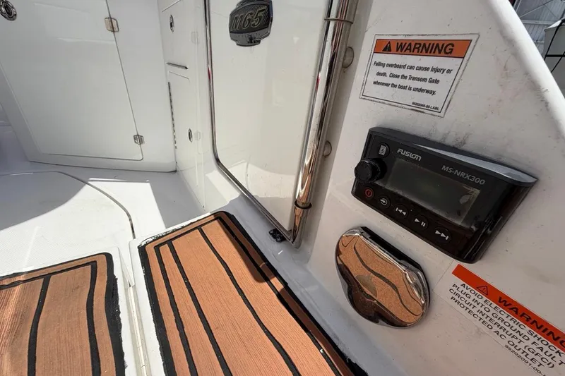 Slide: The Image of 2017 Monterey M-65 boat interior with warning labels and Fusion MS-NRX300 stereo system. - 52
