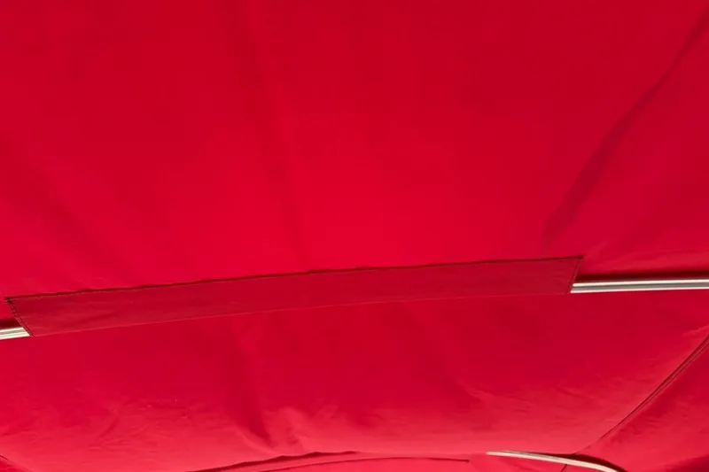 Slide: The Image of Red canopy of a 2017 Monterey M-65 boat, featuring sleek metal support. - 113