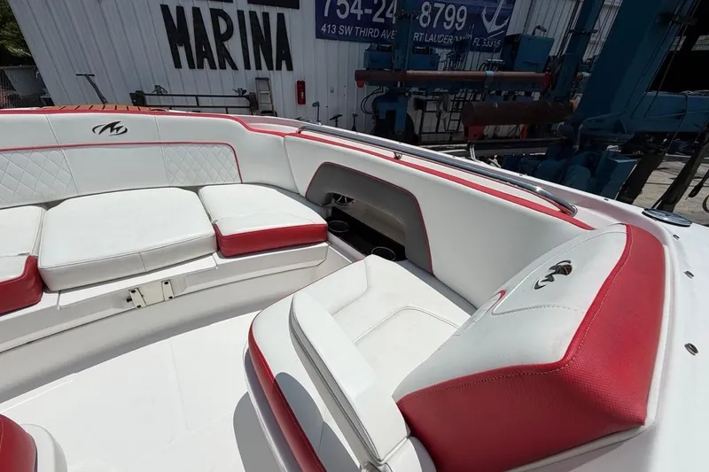 Slide: The Image of 2017 Monterey M-65 boat interior with red and white seating, docked at marina. - 85