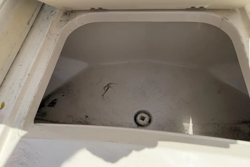 Slide: The Image of Storage compartment in a 2017 Monterey M-65 boat, showing dirt and debris inside. - 111