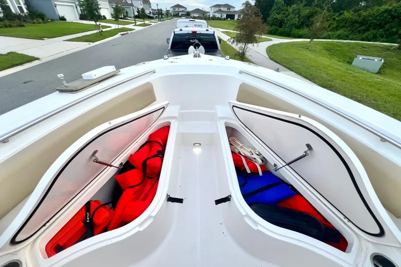 Slide: The Image of 2017 Pursuit C 238 Center Console boat with open storage compartments, life jackets visible. - 70