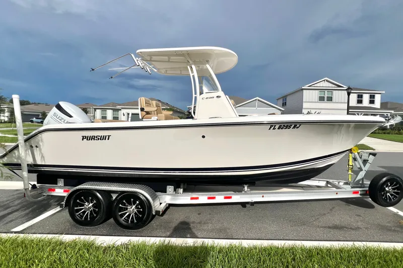 Slide: The Image of 2017 Pursuit C 238 Center Console boat on trailer, parked in residential area. - 1