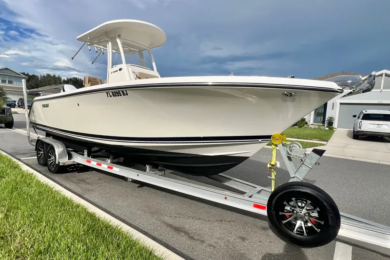 Slide: The Image of 2017 Pursuit C 238 Center Console boat on trailer in suburban neighborhood. - 0