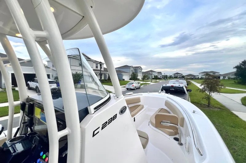 Slide: The Image of 2017 Pursuit C 238 Center Console boat parked in a suburban neighborhood street. - 60